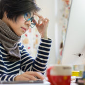 Woman wearing glasses at her computer as she works remotely from home.