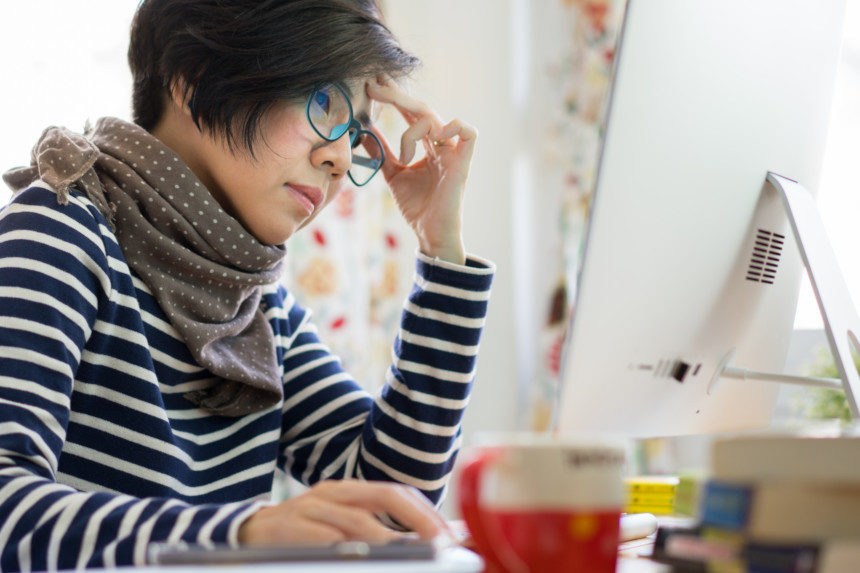 Woman wearing glasses at her computer as she works remotely from home.