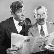 Two men reading a newspaper