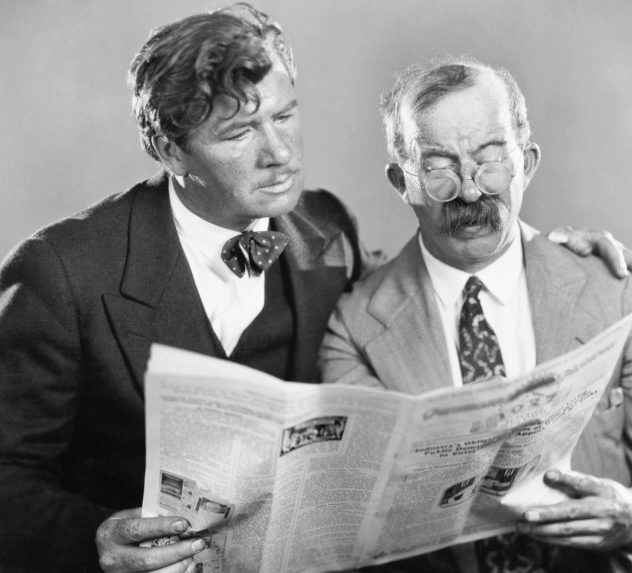 Two men reading a newspaper