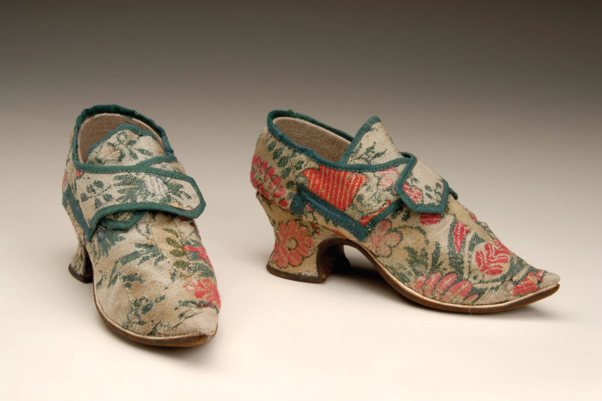 A pair of woolen shoes from the American Revolution. Intricate rose patterns are printed on them.