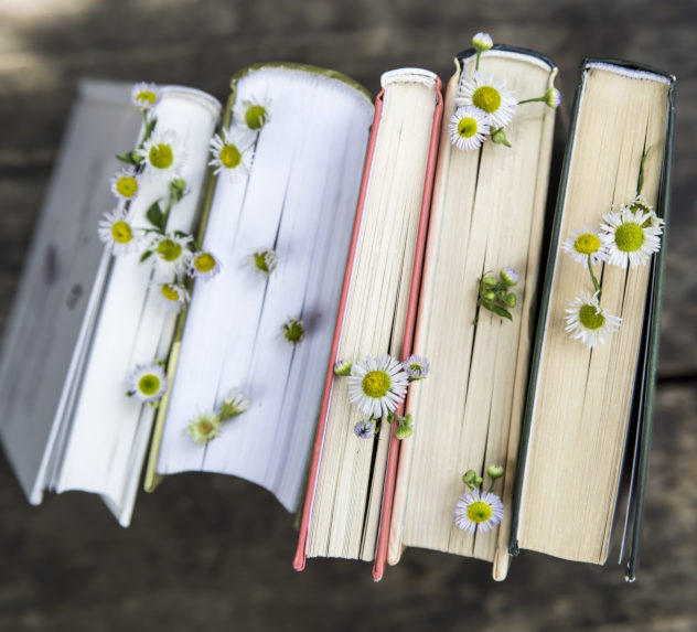 Books on a wooden table with flowers