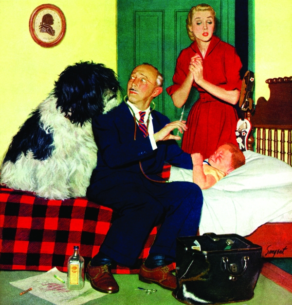 A doctor looks back nervously at a large dog as he prepares to give a shot to a boy during a home visit.