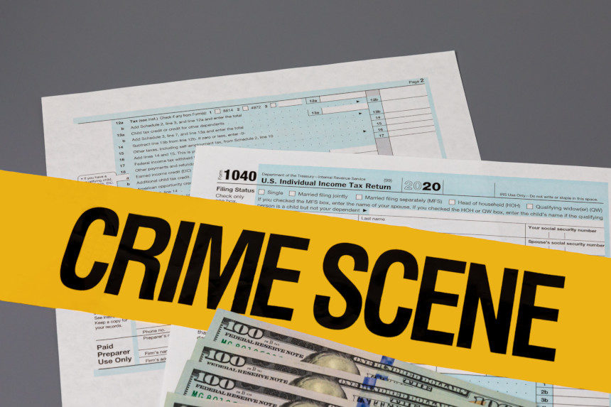 Income tax forms with the words "Crime Scene" superimposed over them.
