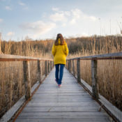 Woman walking on a wooden bridge.