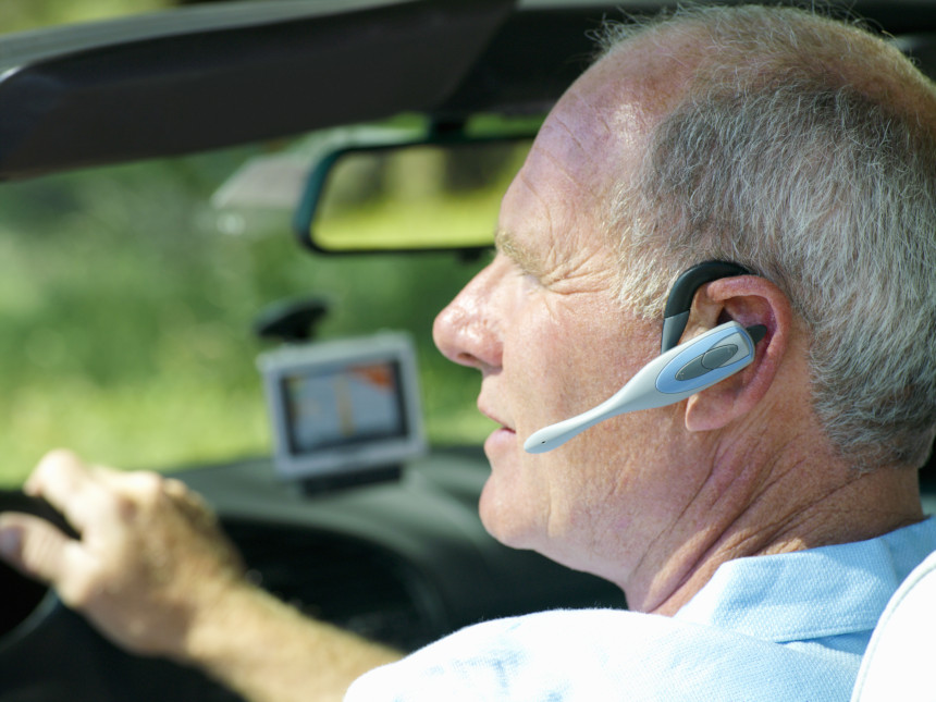 Man speaking into a hands-free phone while driving