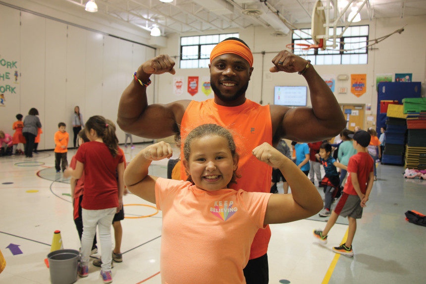 Darrion Crockwell flexes with one of his students during a PE class.