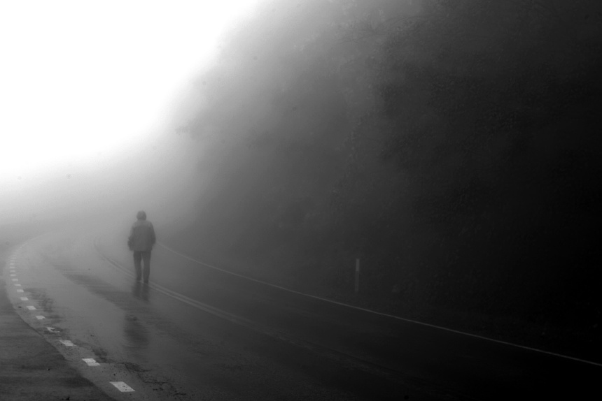 Man Walks Down a Foggy Road
