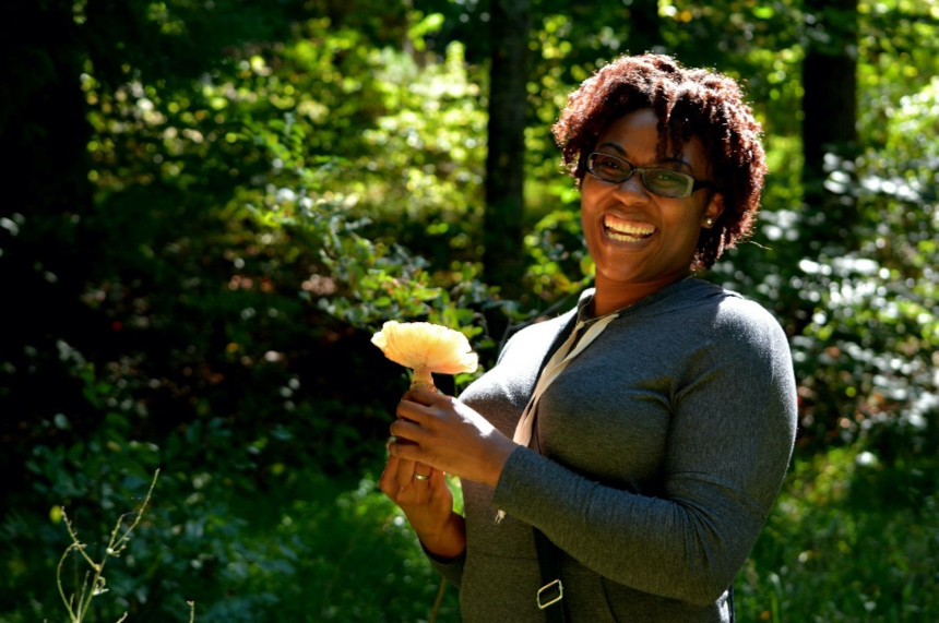 A participant holds an edible honey mushroom on a foraging tour in Asheville with No Taste Like Home (photo by Makyziah Thames for No Taste Like Home)