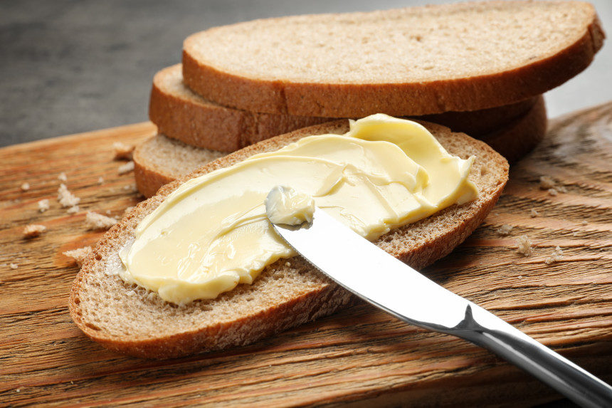 Margarine being spread on a slice of bread
