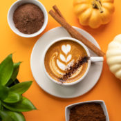 Cup of pumpkin spice latte with pumpkins