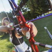 Woman archer prepares to fire a bow.