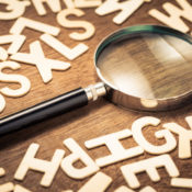 A magnifying glass set in a pile of Latin letters