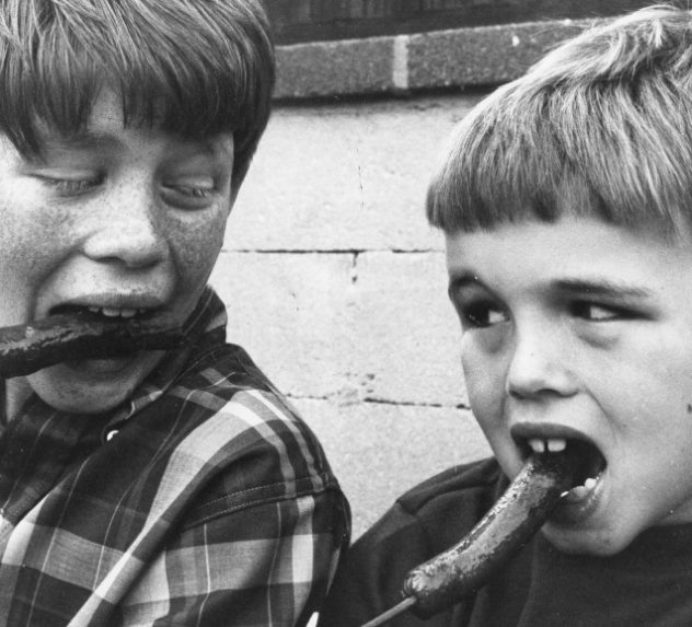 Child actors Ron Howard and Clint Howard eating hot dogs.