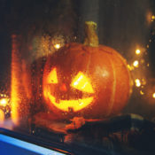 Jack-O-Lantern on a window sill during a rainy Halloween night