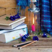 Dictionary next to a candle and a winter scarf