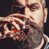 Bearded man drinking whiskey