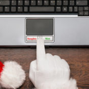 Santa Claus choosing between "Naughty" and "Nice" buttons on a laptop PC