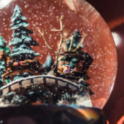 Closeup of a snow globe that displays a family riding a reindeer-drawn sled.