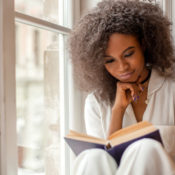 Woman reading a book by her window