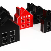 A home marked "scam" stands out among a group of houses.