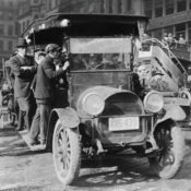 Men riding an overcrowded jitney car in New York City.