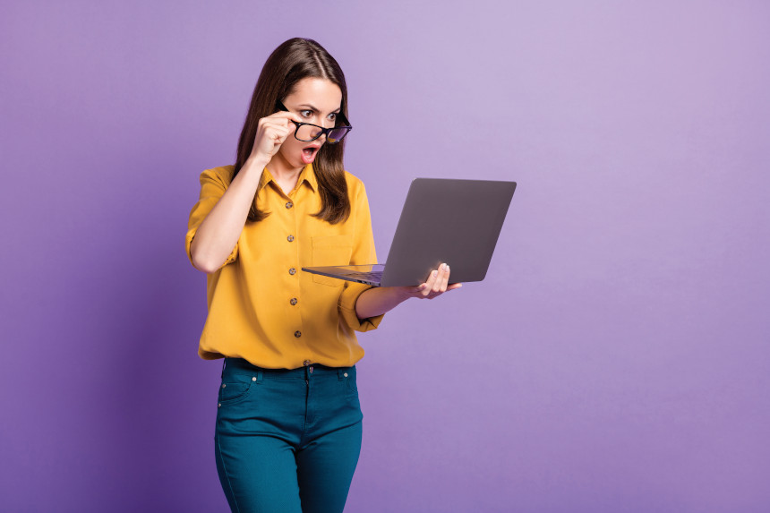 Woman looks shocked at her laptop