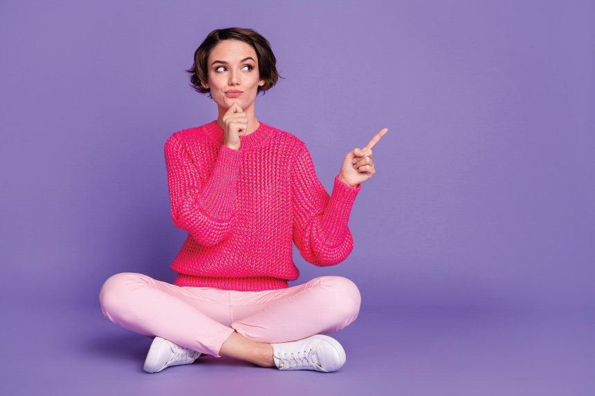 Woman sits with her legs folded