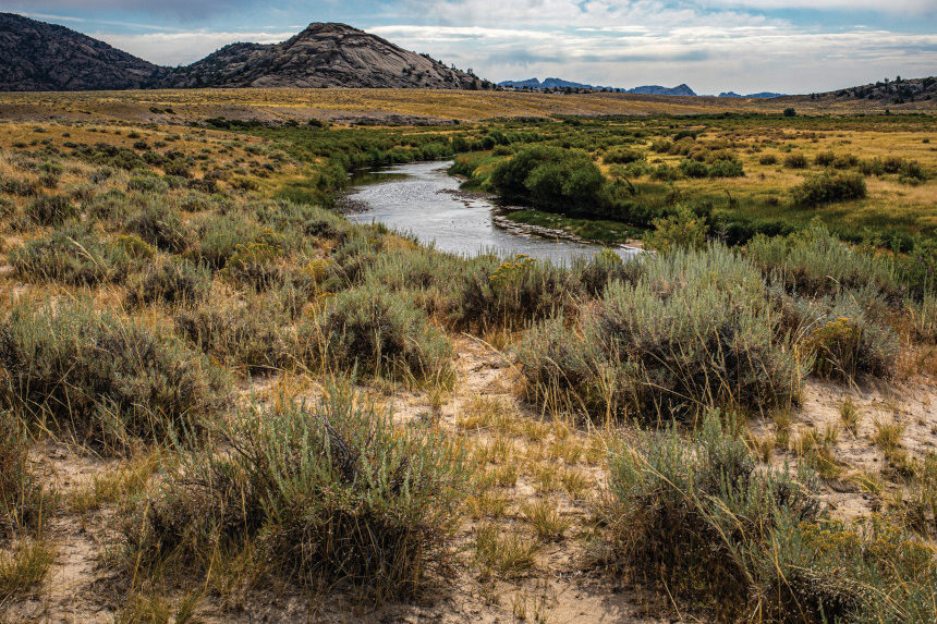 Sweetwater River in the Granite Mountains of Wyoming with sagebrush, sand, and flowing water