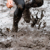 Mud race runner, man running in mud.