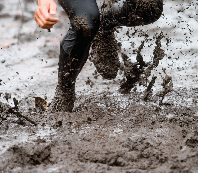 Mud race runner, man running in mud.