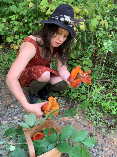 Woman in a hat foraging for mushrooms