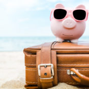 Piggy bank on a suitcase on a beach