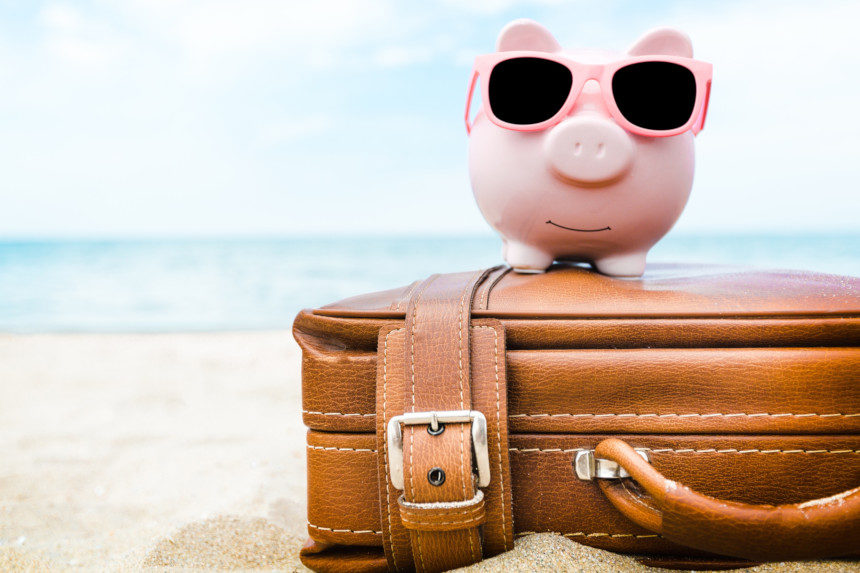 Piggy bank on a suitcase on a beach
