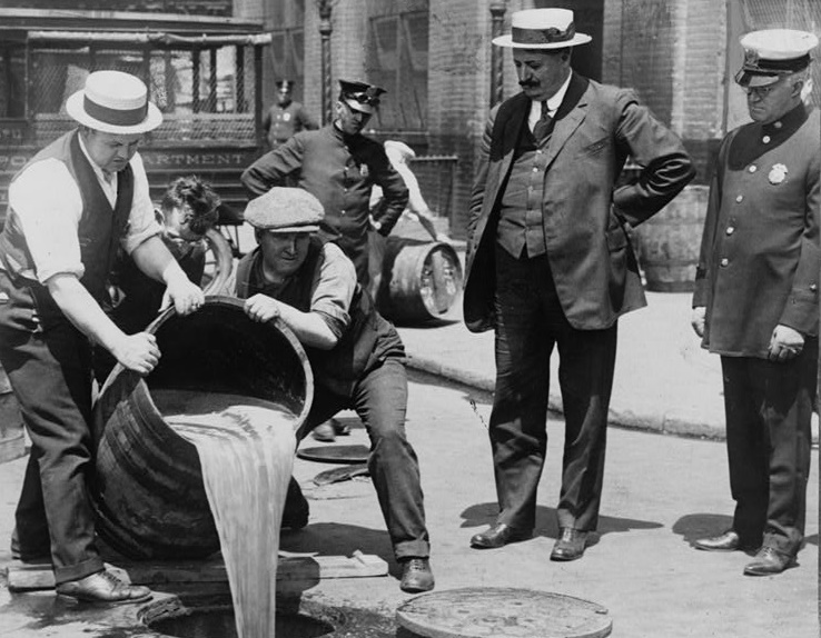 NYPD agents pouring liquor during a Prohibition-era raid