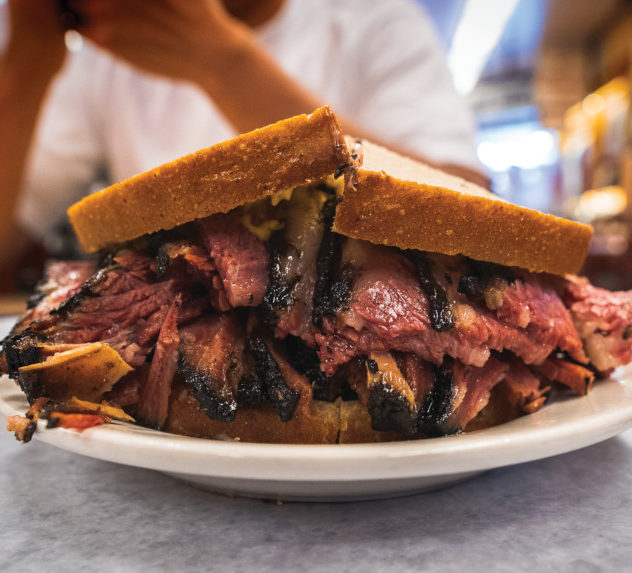 Man eating a pastrami sandich