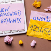 Sticky notes with poor passwords attached to a keyboard.