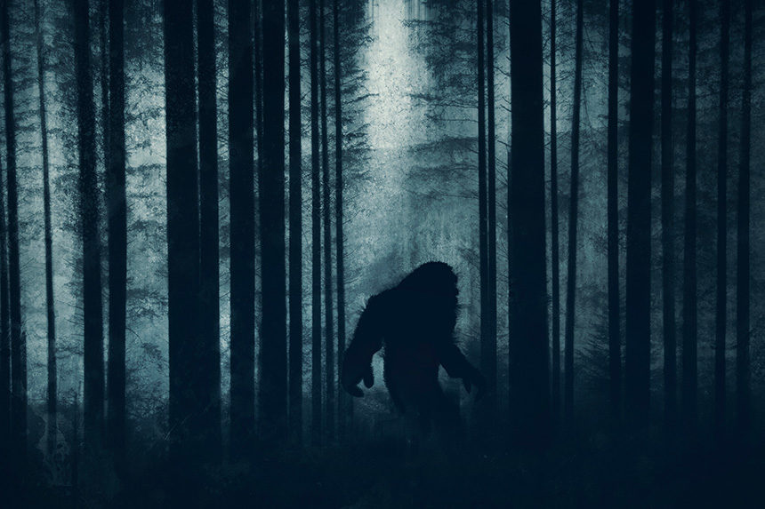 Bigfoot walking through a dark forest