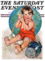 Toddler on beach listening to shell, sand pail near by