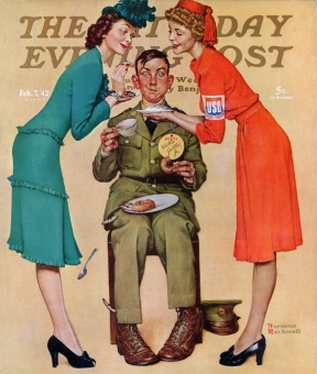 U.S.O. volunteers feed donuts to Willie Gillis