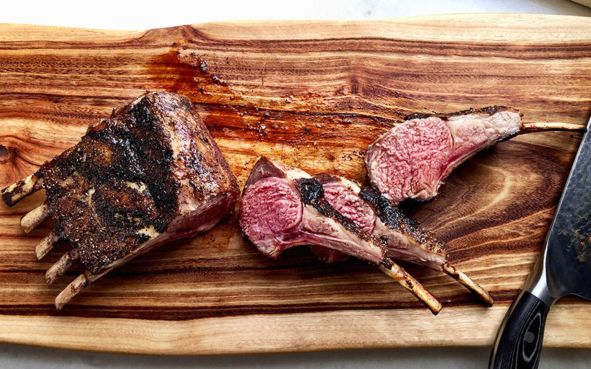 Cuts of barbecue lamb on a wooden cutting board