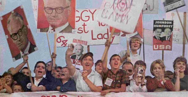 As Goldwaterites welcome their man to St. Louis, rivals Johnson and Humphrey smile calmly from poster held by a Democratic interloper. Photo credit: Burt Glinn The Saturday Evening Post, October 24, 1964.