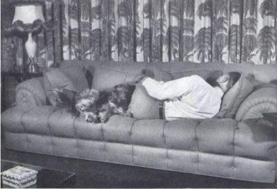 Man resting on a couch with his dog.