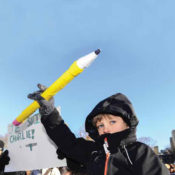 A child holding a pencil during a Charlie Hebdo support march.