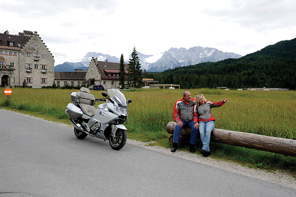 Couple sitting near motorcycle on Romantic Road in Germany