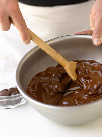stirring chocolate in metal bowl