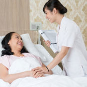 Hospice volunteer caring for a female patient lying in bed