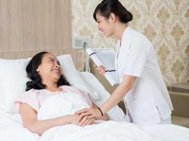 Hospice volunteer caring for a female patient lying in bed