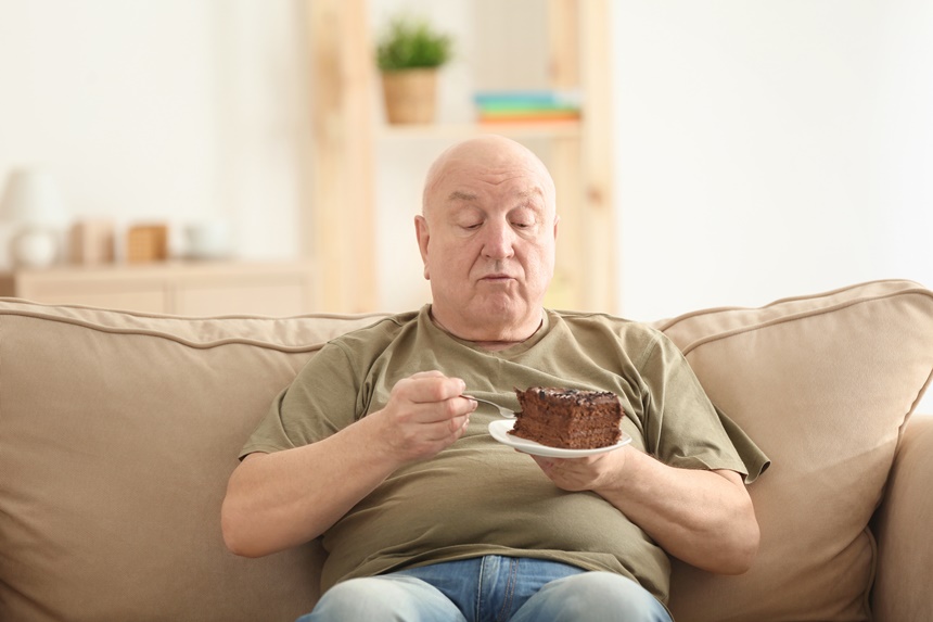 Man eating cake on a couch.