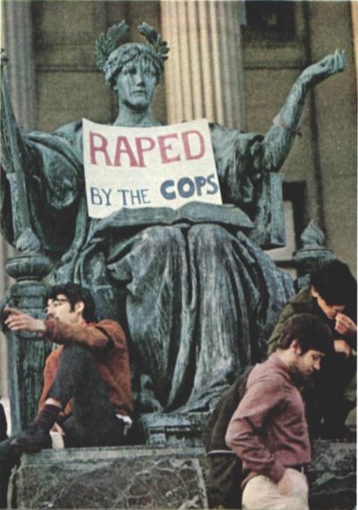 College students sit on the foot of a statue of Justice